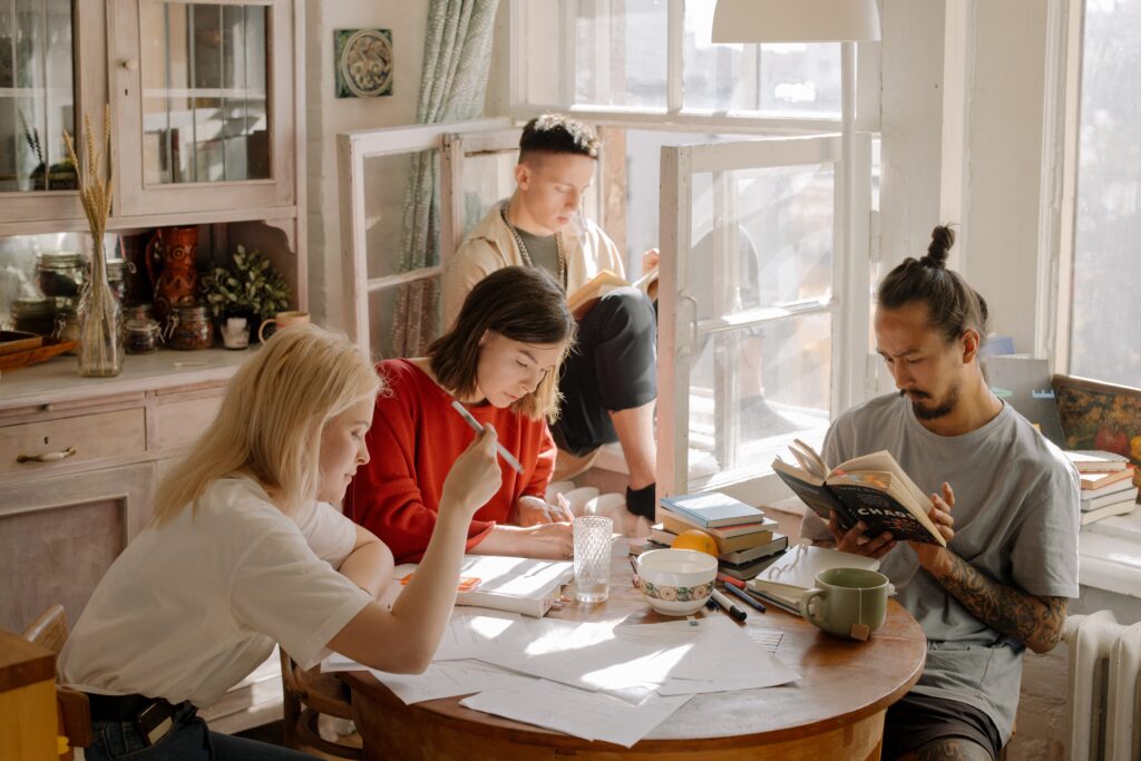 Group of students studying seated around a round table.